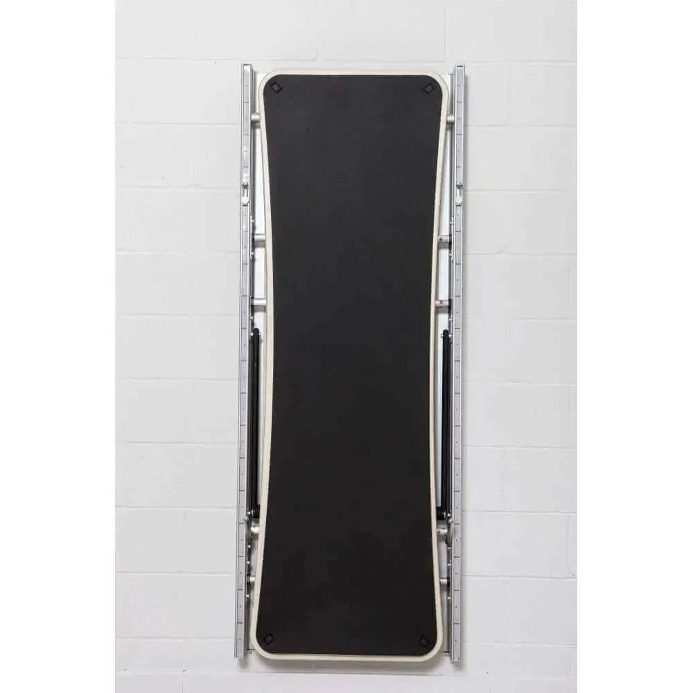 Vue arrière Pilates Wall Unit 5-en-1 avec plateau incliné noir replié verticalement soulignant conception compacte pliable