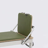 Reformer Pilates AERO Olive vue latérale avec dossier rembourré vert olive, plateau bois clair et cadre blanc