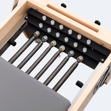 Vue supérieure cinq ressorts torsadés couleurs résistance rail noir rouleaux guidage reformer Pilates