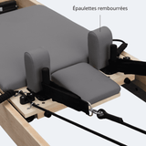 Épaulettes rembourrées tissu gris foncé coutures apparentes plateforme centrale sangles boucles reformer