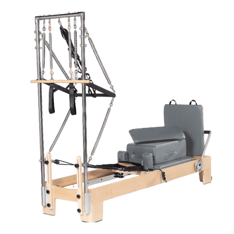 Reformer Pilates ESSENTIAL avec tour en érable massif verni, vue trois-quarts gauche sur fond blanc