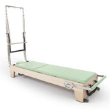 Reformer Pilates Elite en bois clair avec coussins vert menthe et finition apaisante